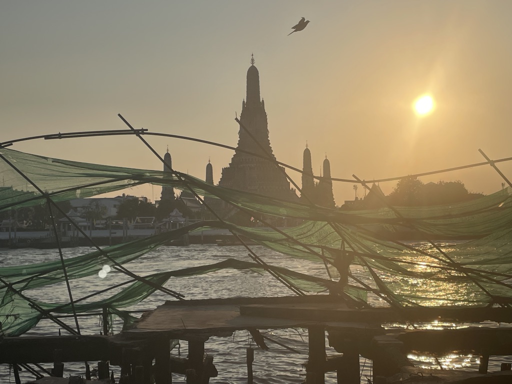 Along the Chao Phraya -view of Wat Arun at sunset through fishing nets